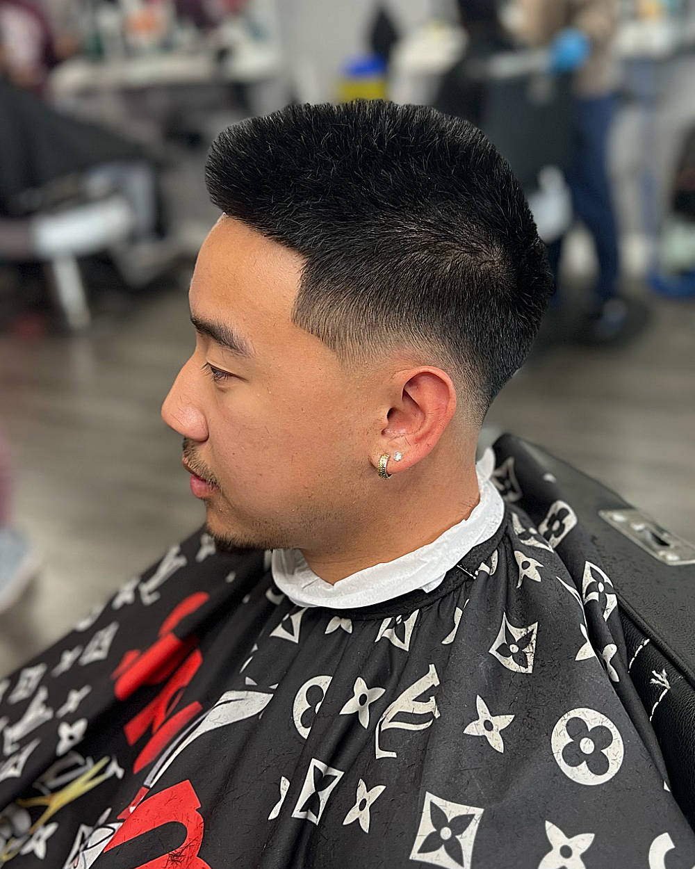 Bald drop fade buzz cut: short, textured top with sharp fade from sides, clean bald transition, modern, neat.