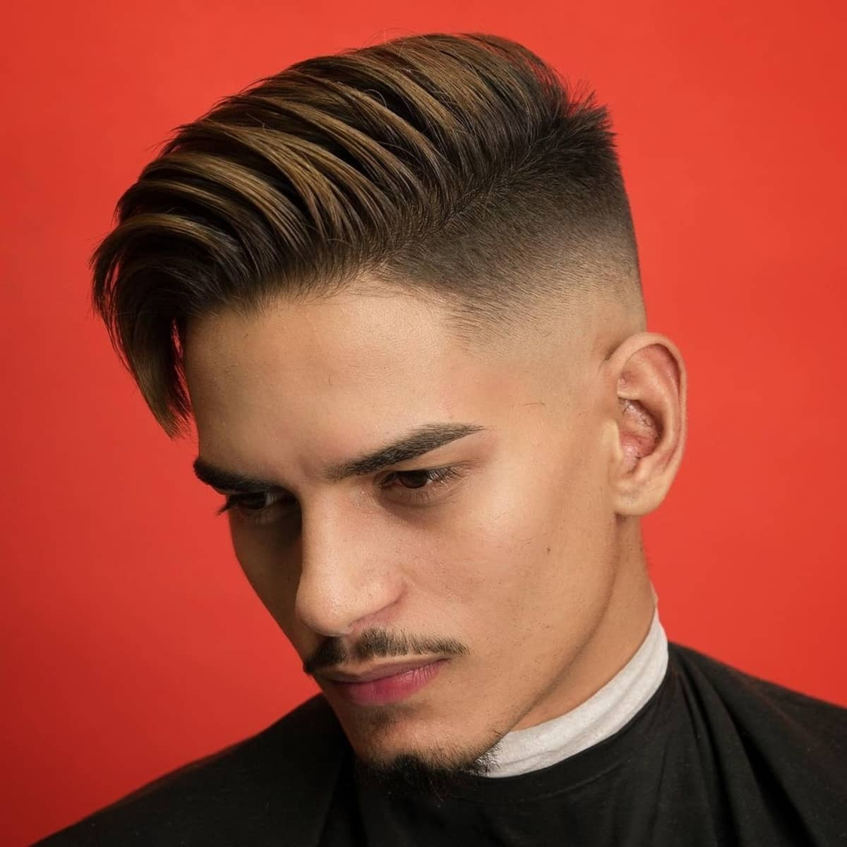 Drop fade undercut with sharp separation, longer disconnected top, smooth texture, gradual fade from mid-lengths to skin.