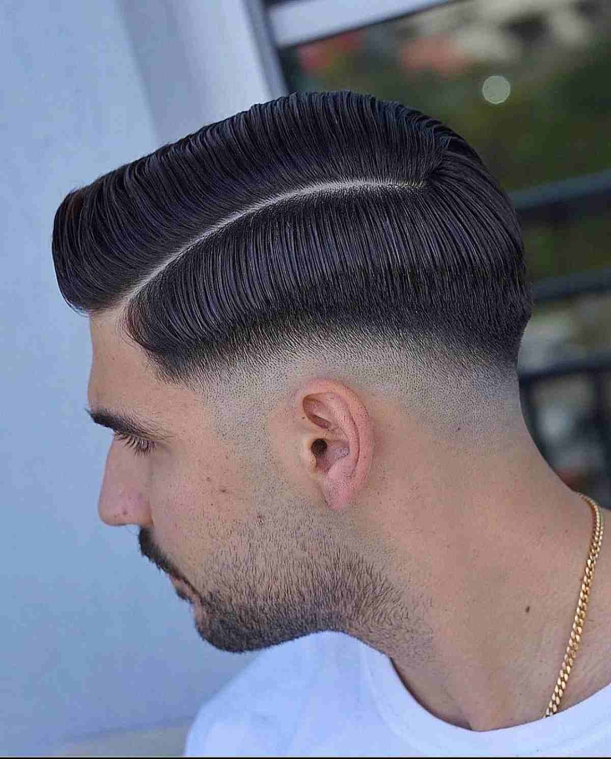 Drop fade with goatee: sleek, combed-over top, sharp fade, defined goatee, polished texture.
