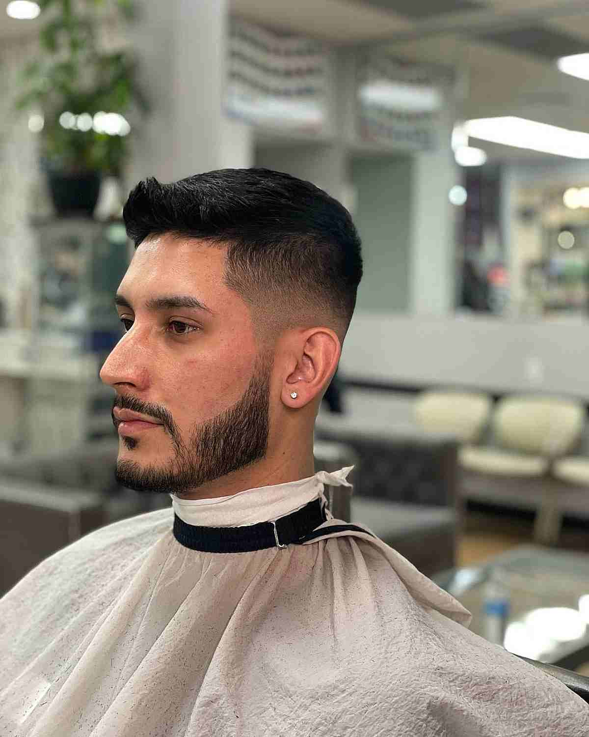 Drop fade with quiff: forward/upward front lift, visible quiff structure, textured top, sharp fade transition.