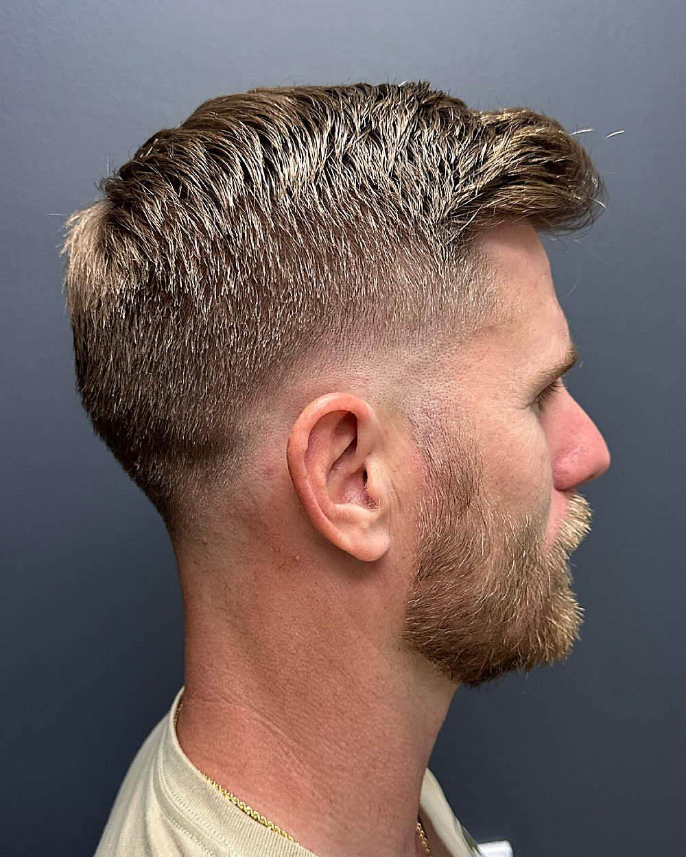Drop fade with textured, swept-back Ivy League top; clean, gradual fade from longer sides to nape.