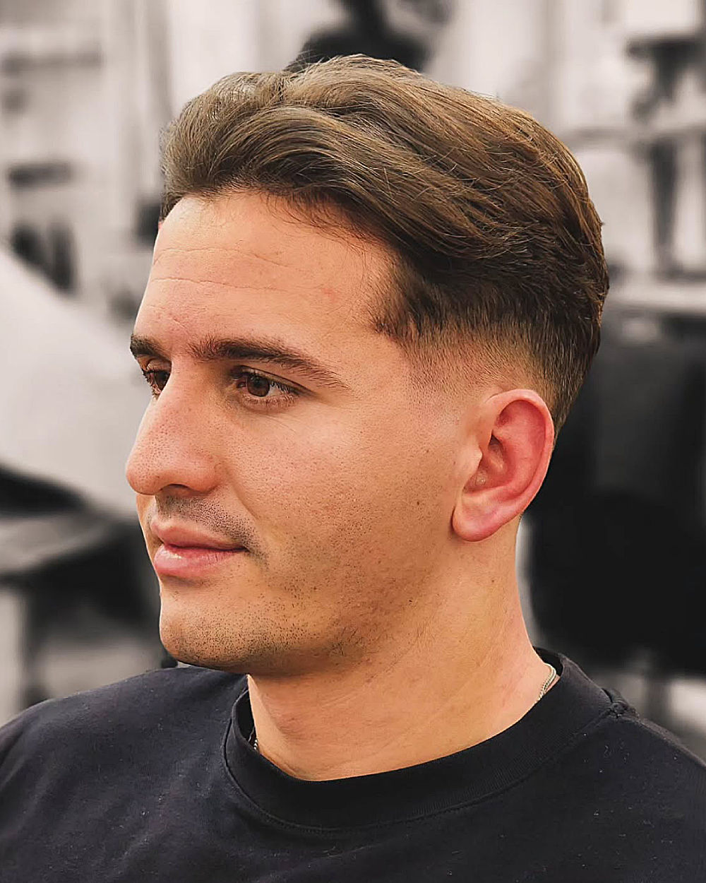 Medium-length side-parted hair with smooth texture, low fade, and clean, sharp lines.