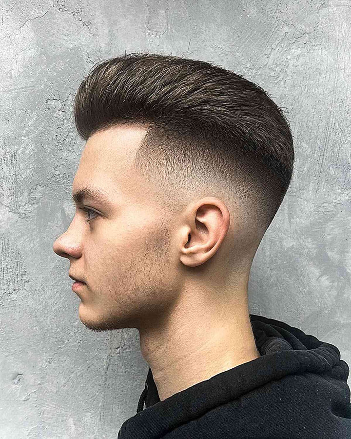 Mid drop fade with blow-dried volume top, sharp height contrast, textured, sleek sides.
