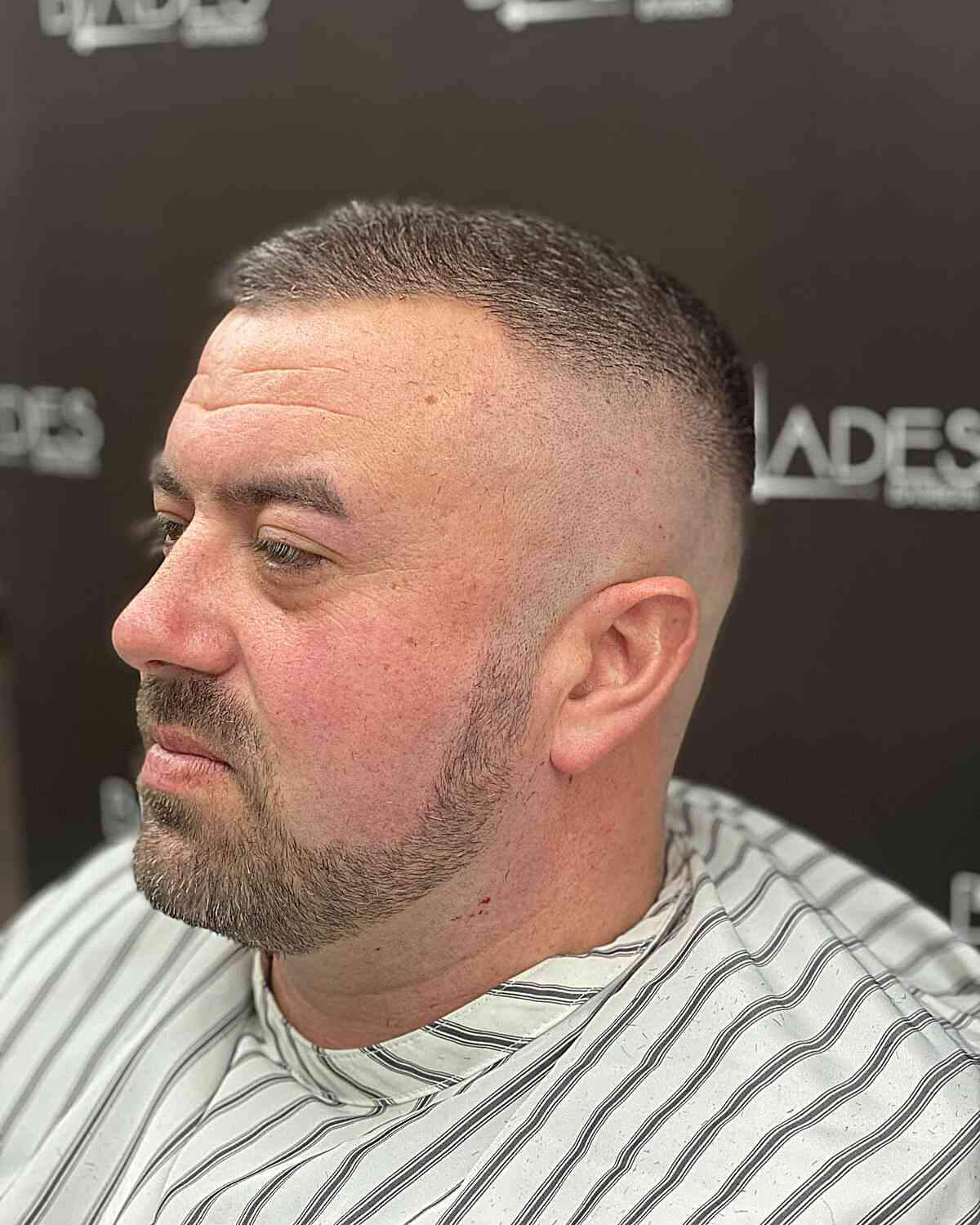 Mid Drop Fade with Tapered Sideburns: Textured top, sharp sideburn taper, clean mid fade.