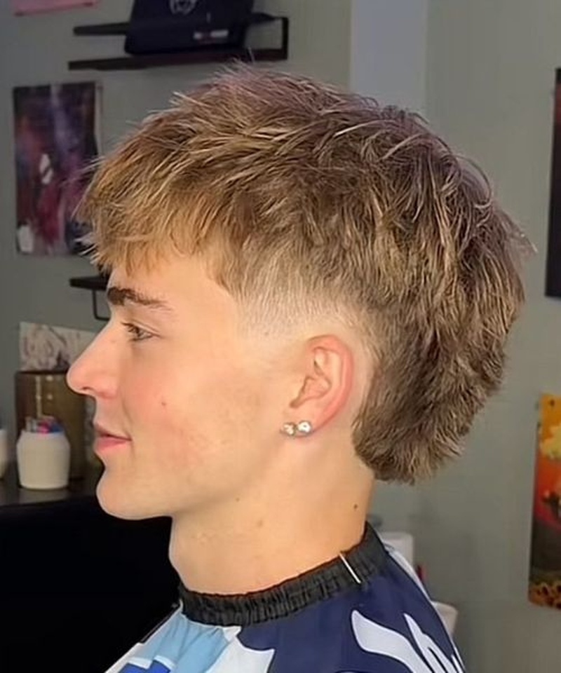 Mid taper fade mullet men's haircut with short sides, longer back, and textured top.