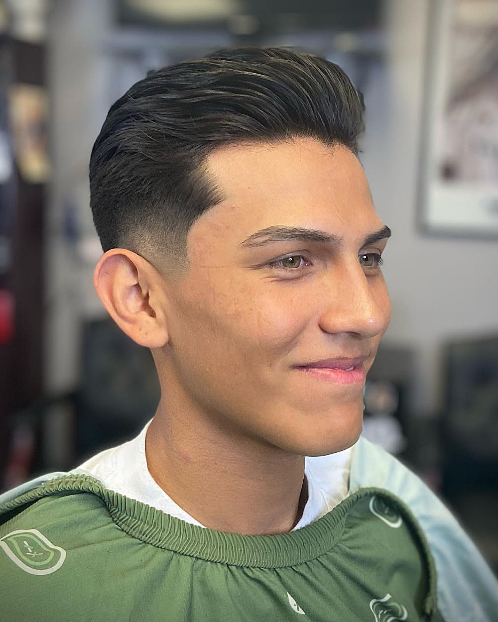 Pompadour Drop Fade: Slicked-back top with volume, textured waves, sharp drop fade from temple to nape, clean side part.