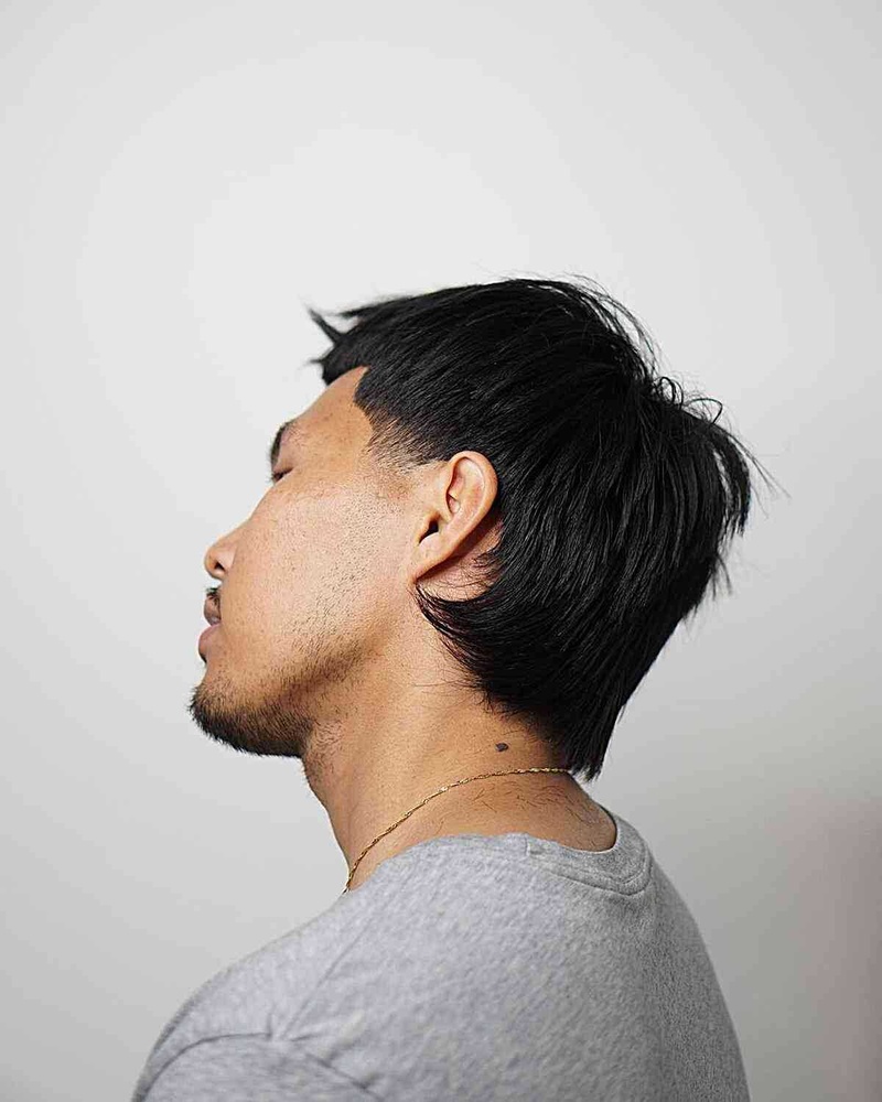 Man with a short-back-and-sides mullet haircut showing medium-length textured haircut, sharp fade, and layered top.