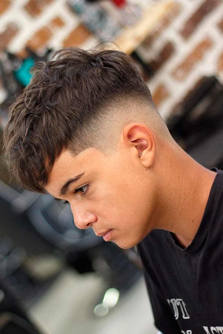 Textured, voluminous top with a sharp low fade.